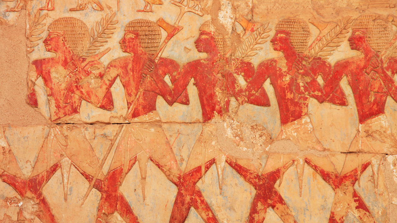 Forntidfa egyptisk relief där en rad människor i trekvartsprofil bär på sädesax.