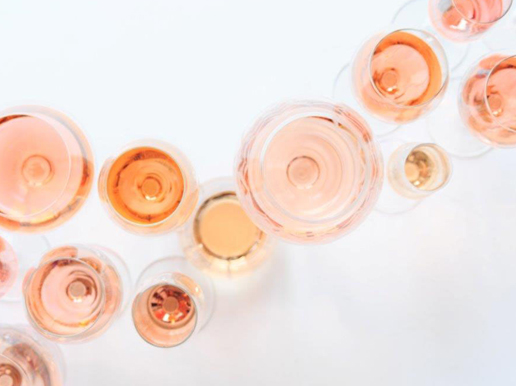 Tolv glas rosévin sedda ovanifrån. Nyanserna varierar från blekt rosa till orange och ljusrött.